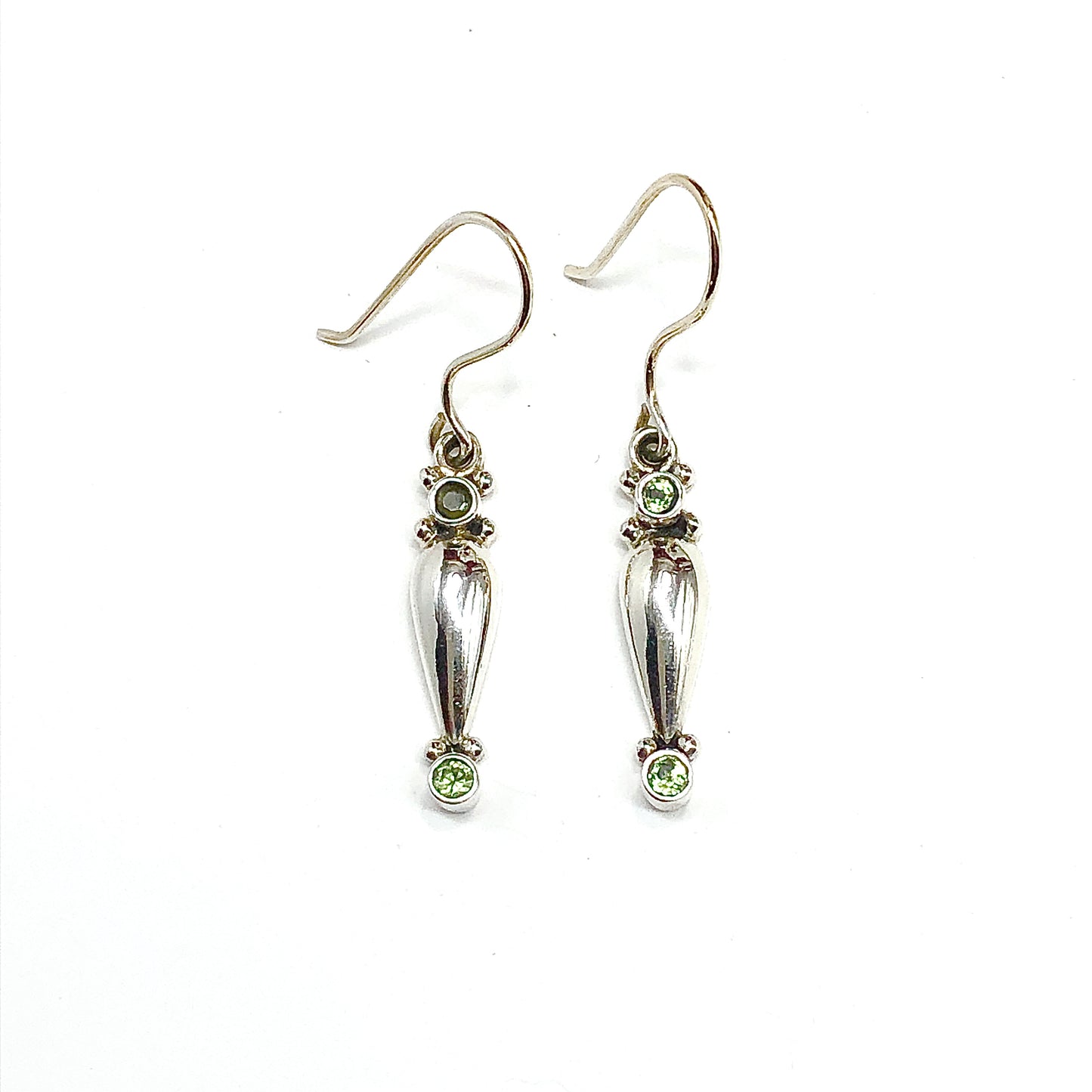 Silver earrings with green gemstones on a white background