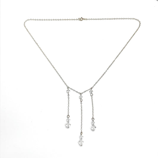 Silver necklace with dangling cryatal bead charms on a white background