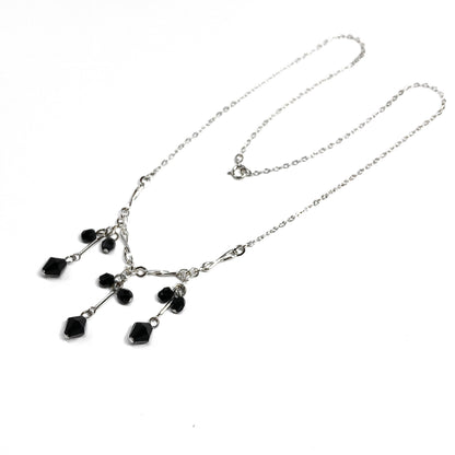 Sterling Silver tassel necklace with black crystal stones on a white background