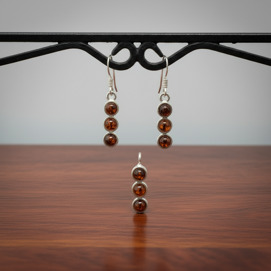 Pair of 925 sterling silver earrings with amber gemstones on a wooden surface.
