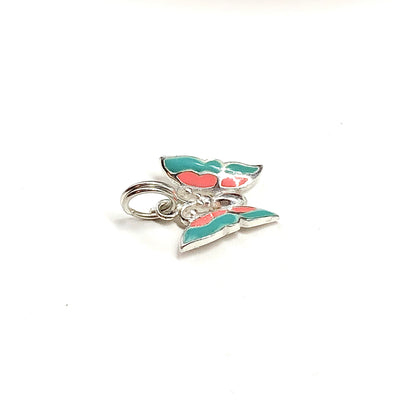 Small silver charm with green and red accents on a white background
