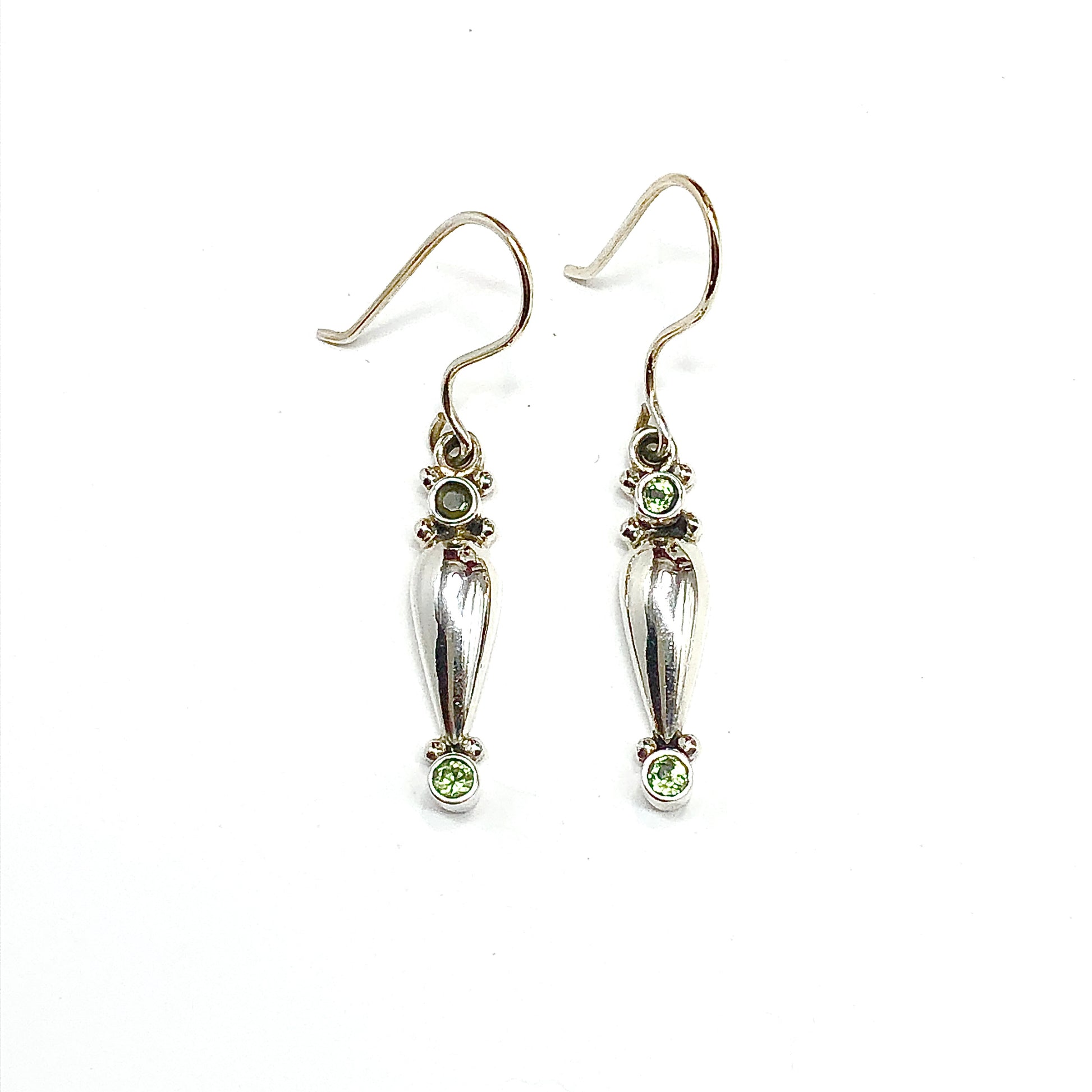 Silver earrings with green gemstones on a white background