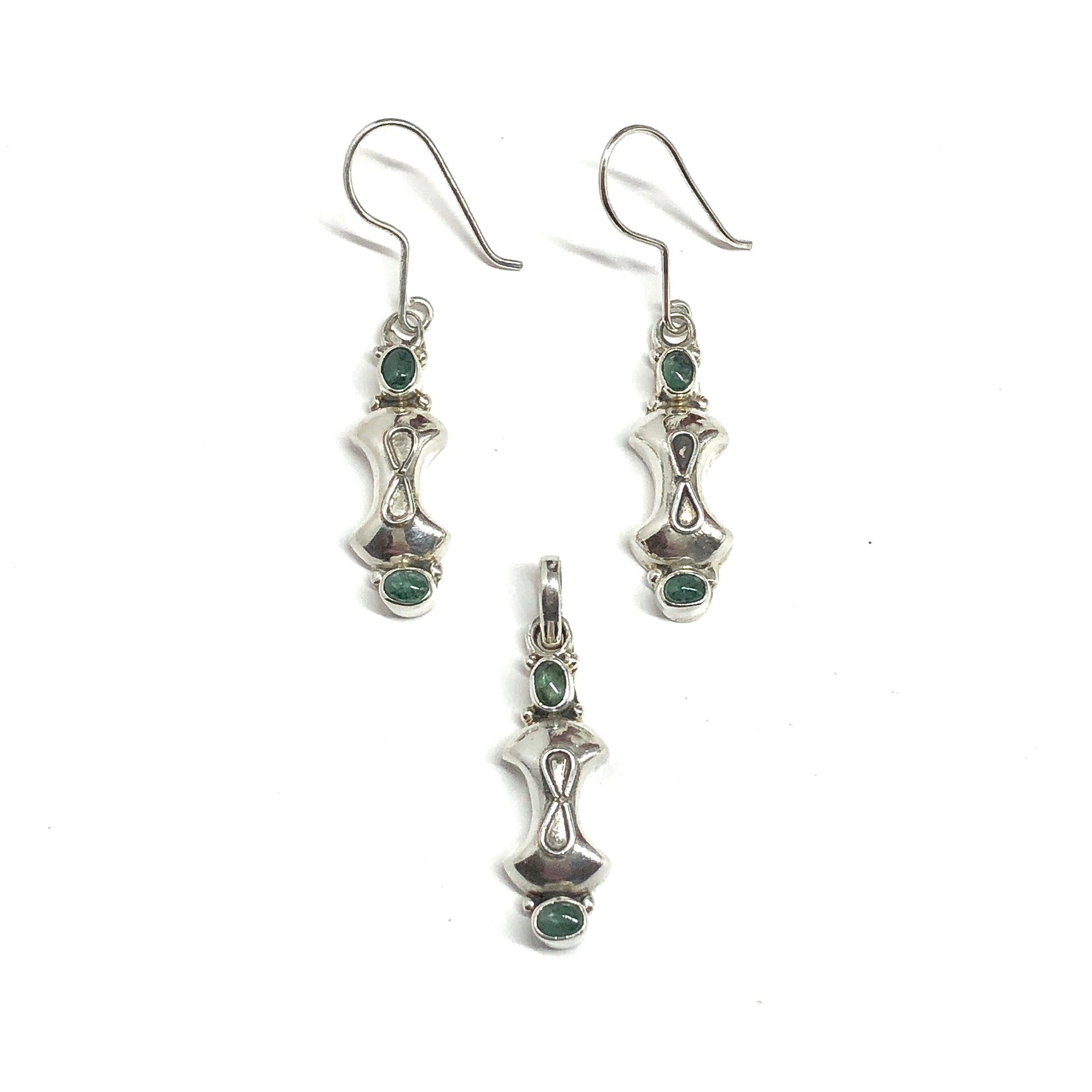 Silver earrings and pendant with green gemstones on a white background