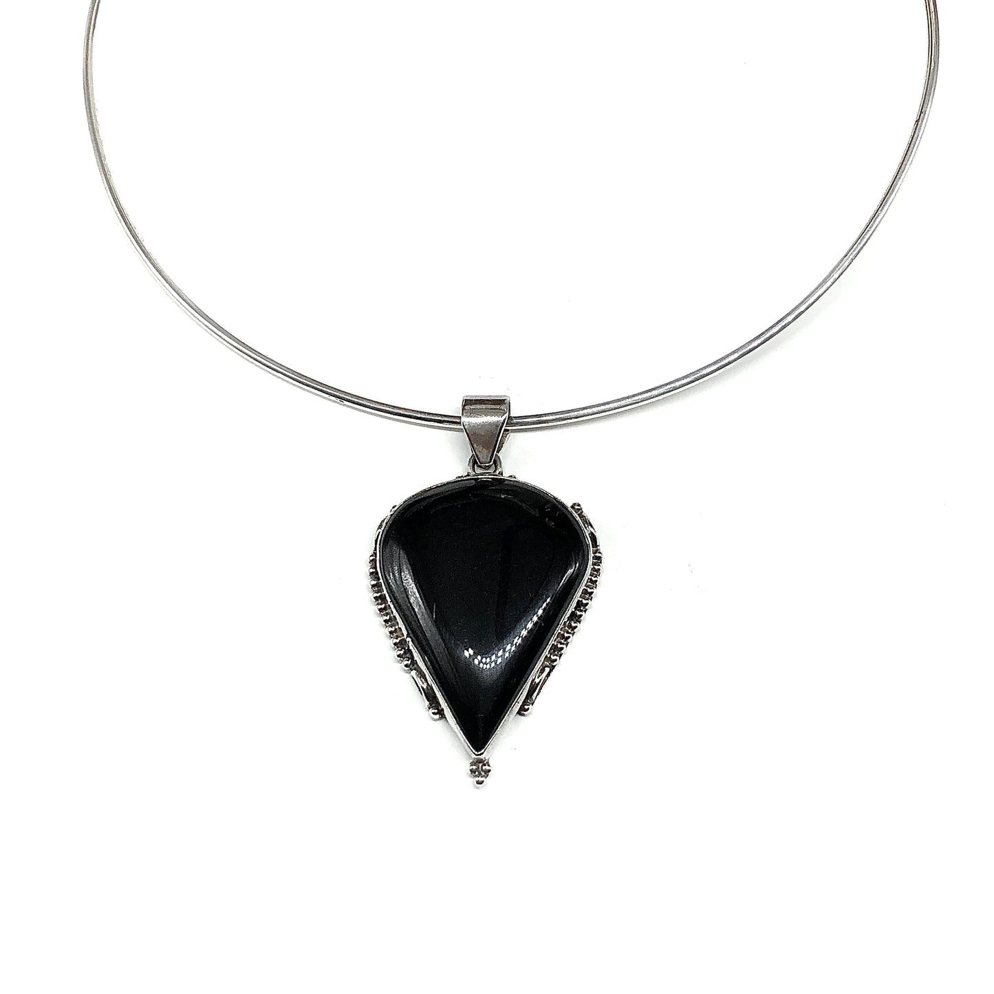 A 925 Sterling Silver necklace featuring a teardrop-shaped black onyx pendant with a unique designed Sterling Silver bezel setting.