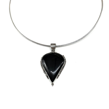 A 925 Sterling Silver necklace featuring a teardrop-shaped black onyx pendant with a unique designed Sterling Silver bezel setting.