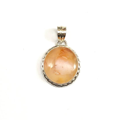 A round fiery orange-colored cabochon carnelian stone pendant set in a 925 silver bezel with a rope border.